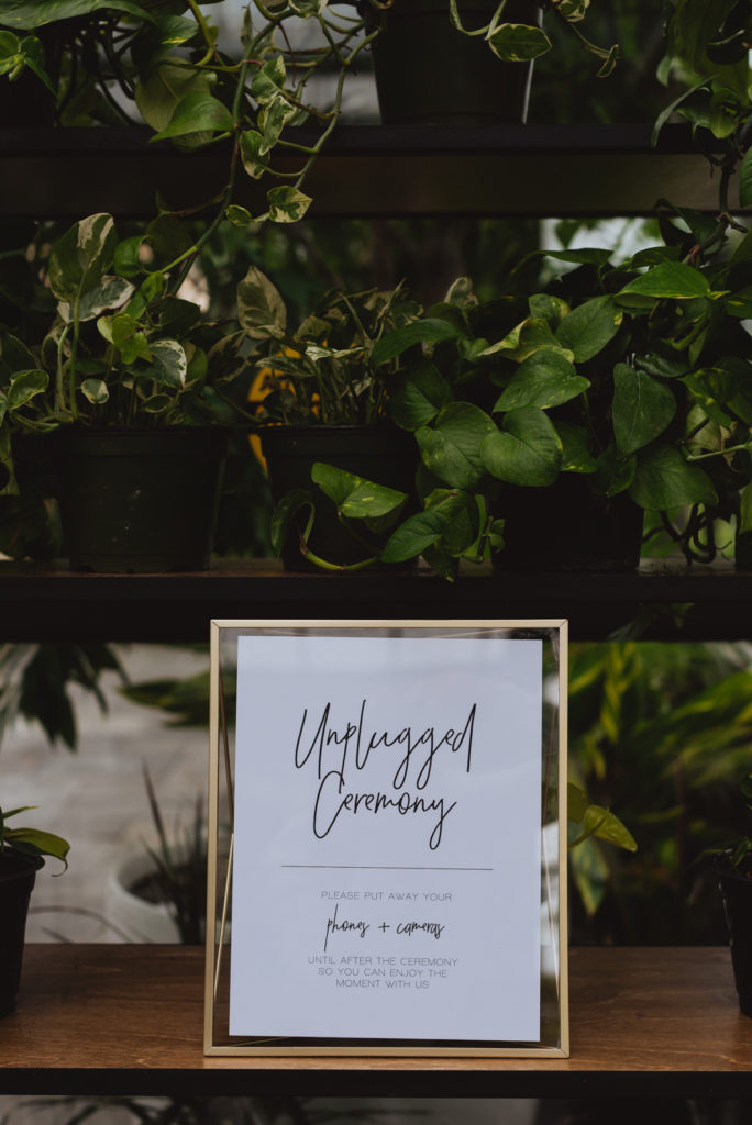 unplugged ceremony sign amongst plants