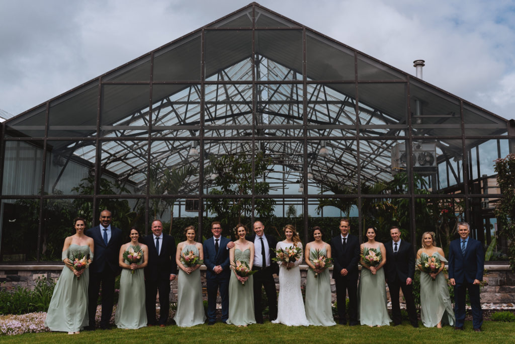 wedding party outside greenhouse in sage green dresses
