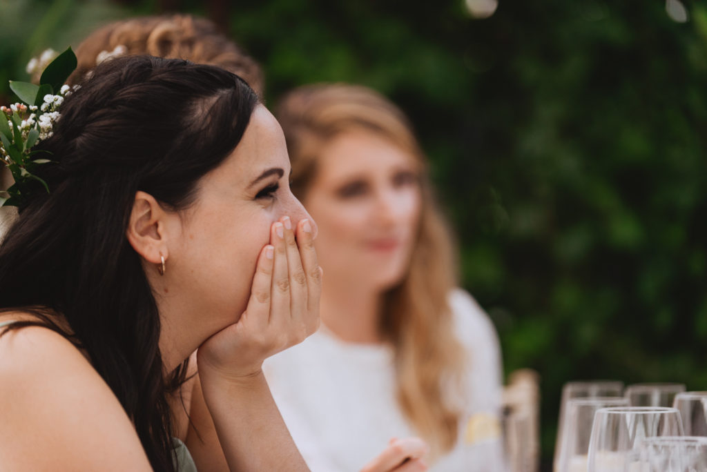 bridesmaid trying not to laugh during wedding speeches
