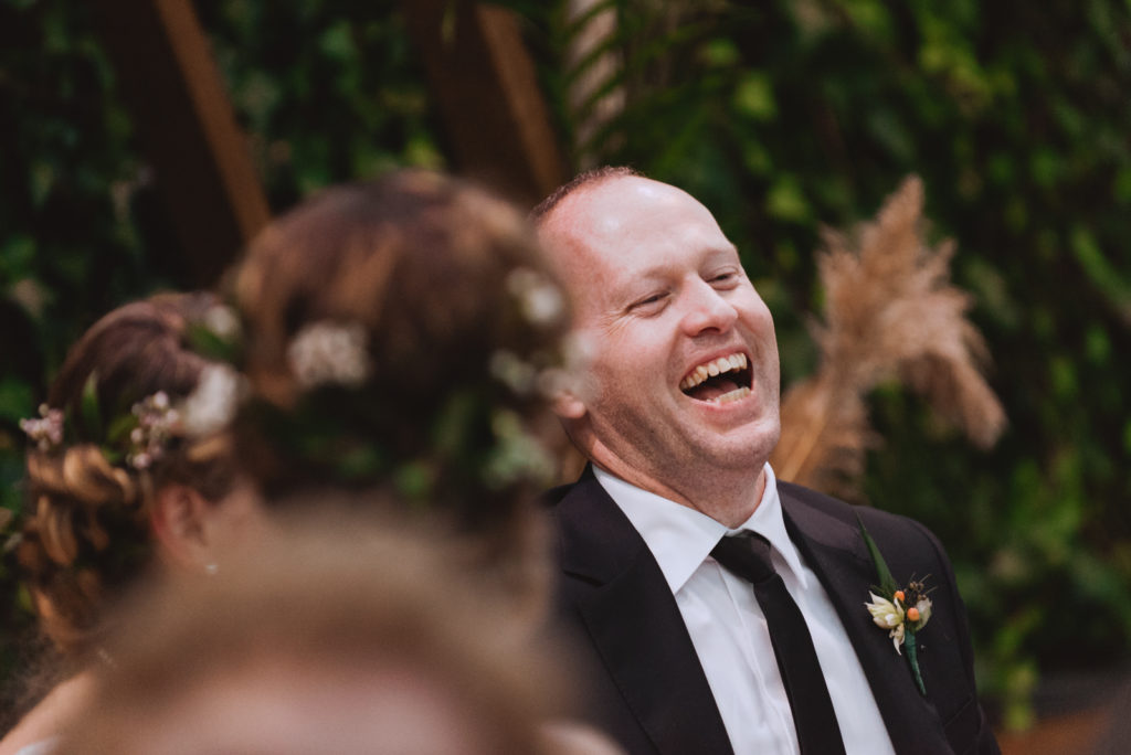 groom laughing during wedding reception speeches