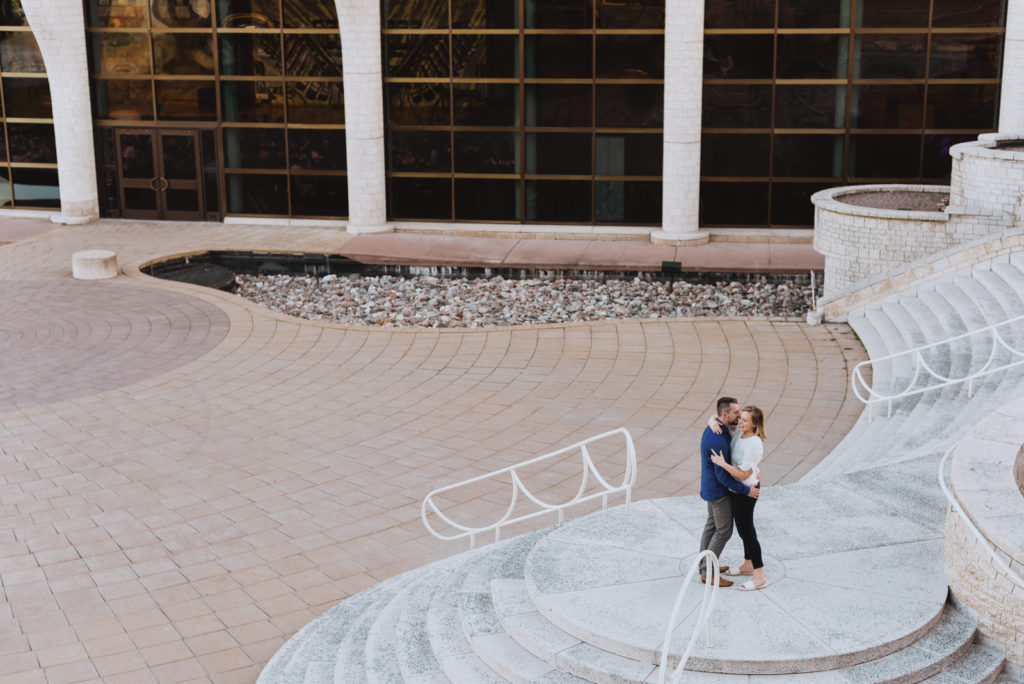 engaged couple hugging on staircase outside Museum of History