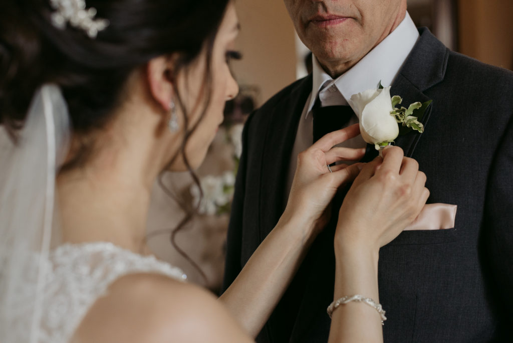 bride putting on her dad's boutonniere