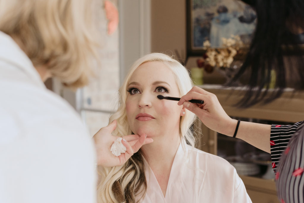 makeup artists putting on bridesmaid's makeup