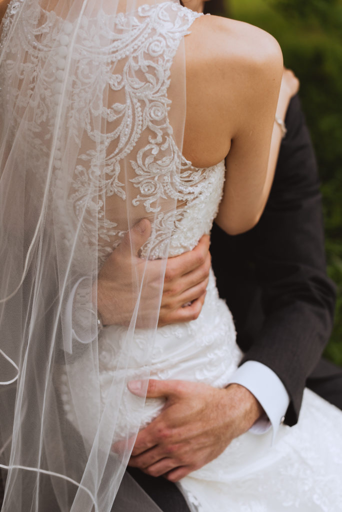 groom's hands around the bride's waist