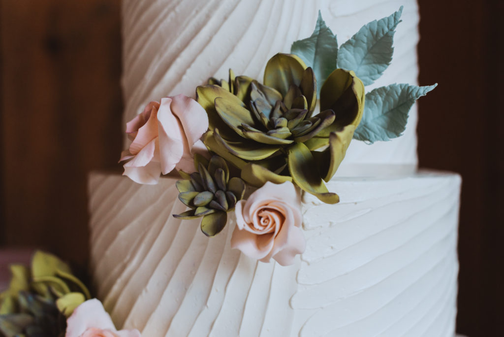 wedding cake with succulents and roses