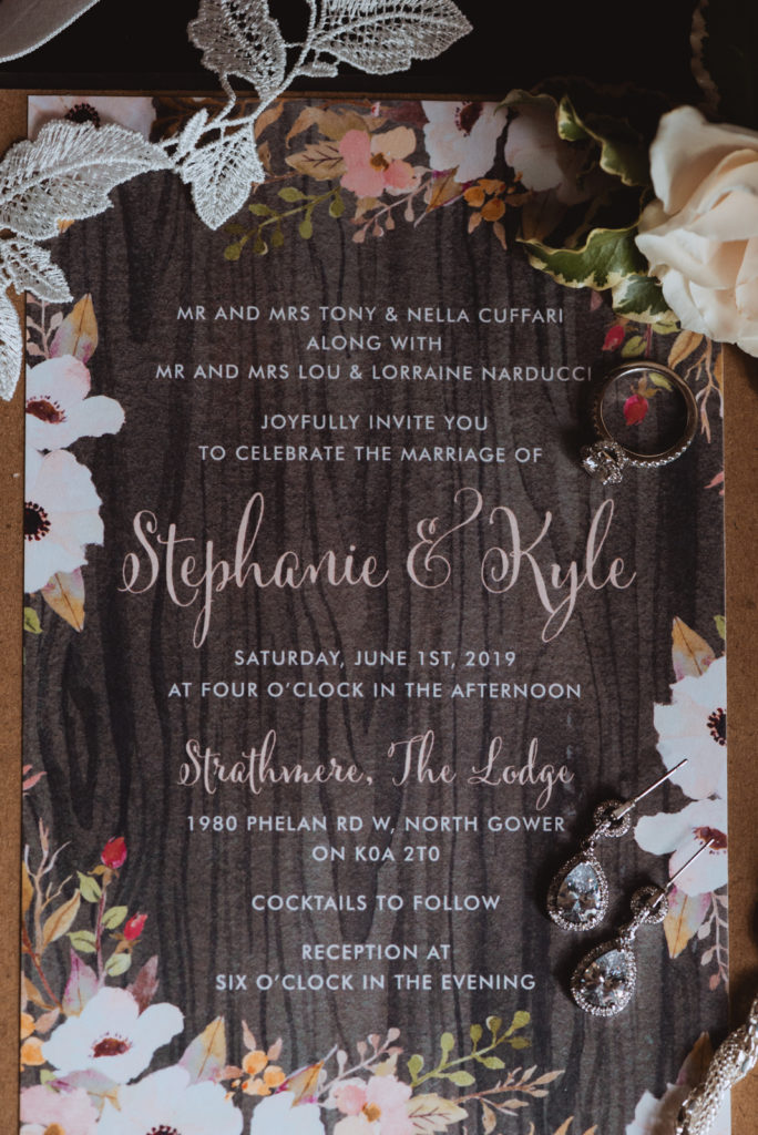 flat lay of wedding invitation and bride's jewellery