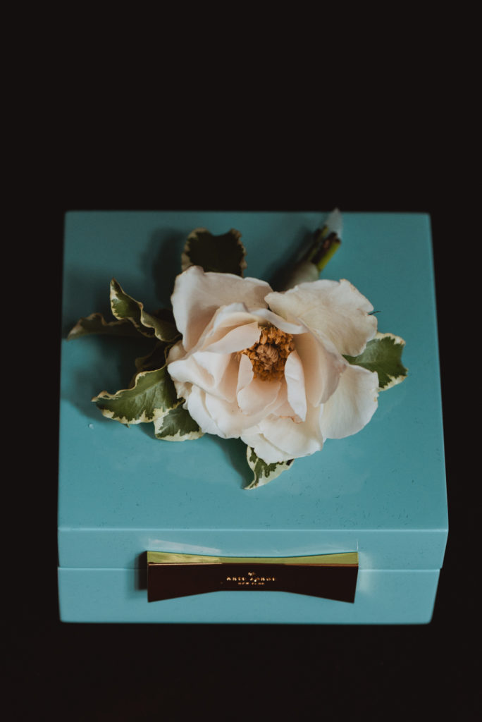 boutonniere resting on blue kate spade box
