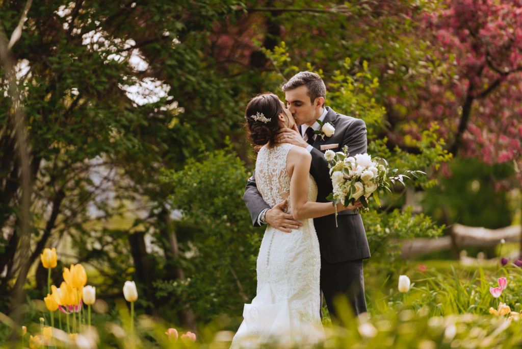bride and groom kissing in the garden