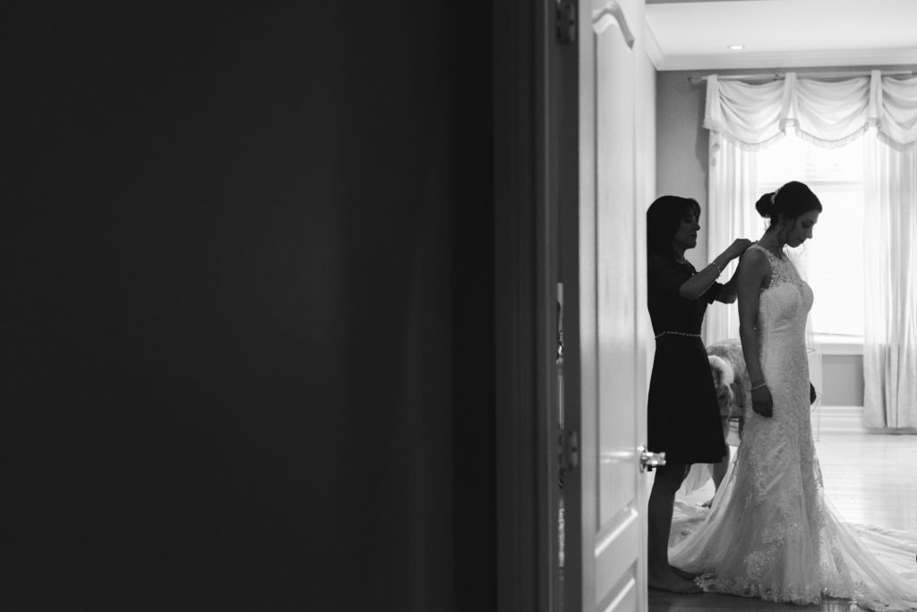 silhouette of bride's mother tying up the bride's wedding dress