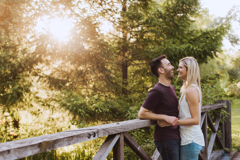 engaged couple on wooden bridge laughing