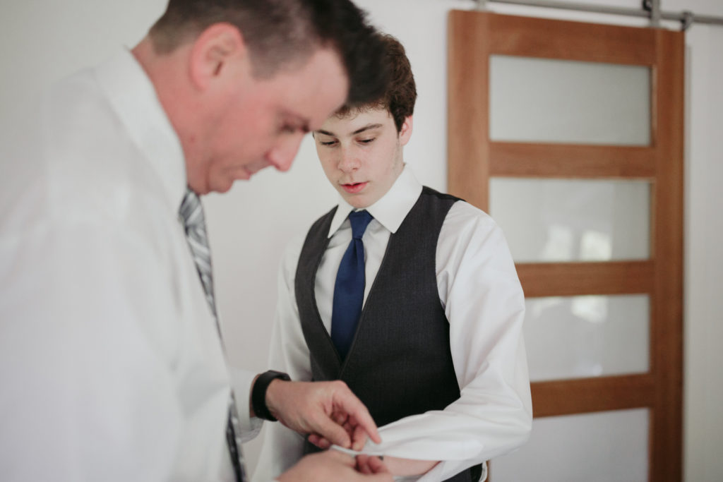 groom helping his son put on his cufflinks