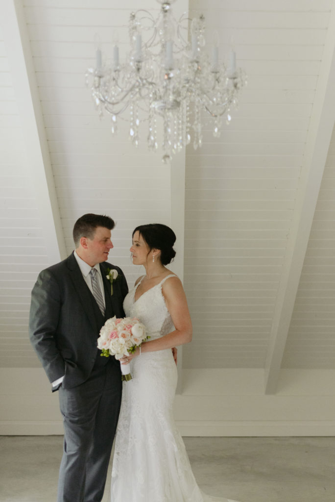 bride and groom in the guesthouse at Le Belvedere under chandelier