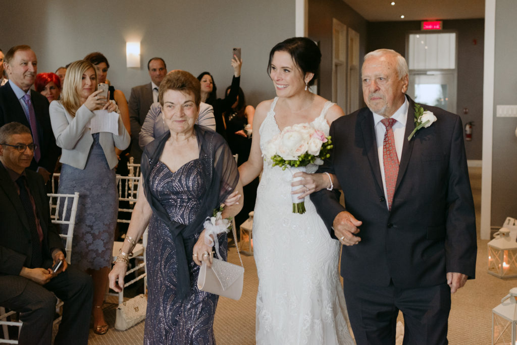 bride and her parents walking down the aisle