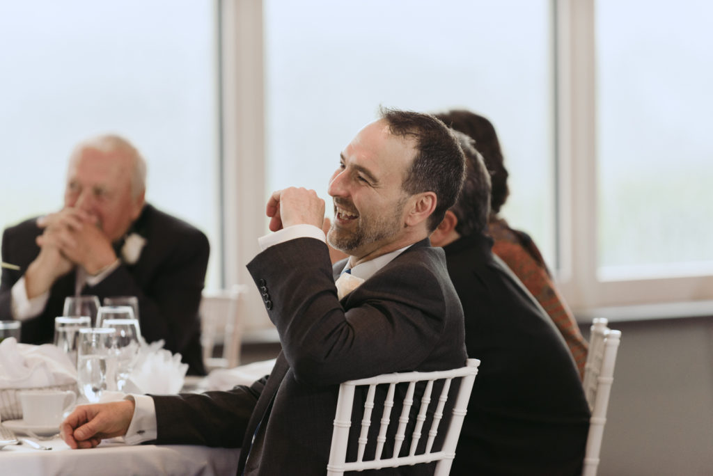 brother of the bride laughing during wedding reception