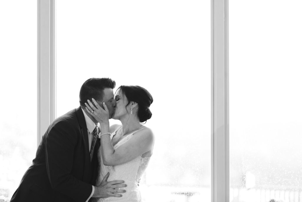 bride and groom kissing at head table