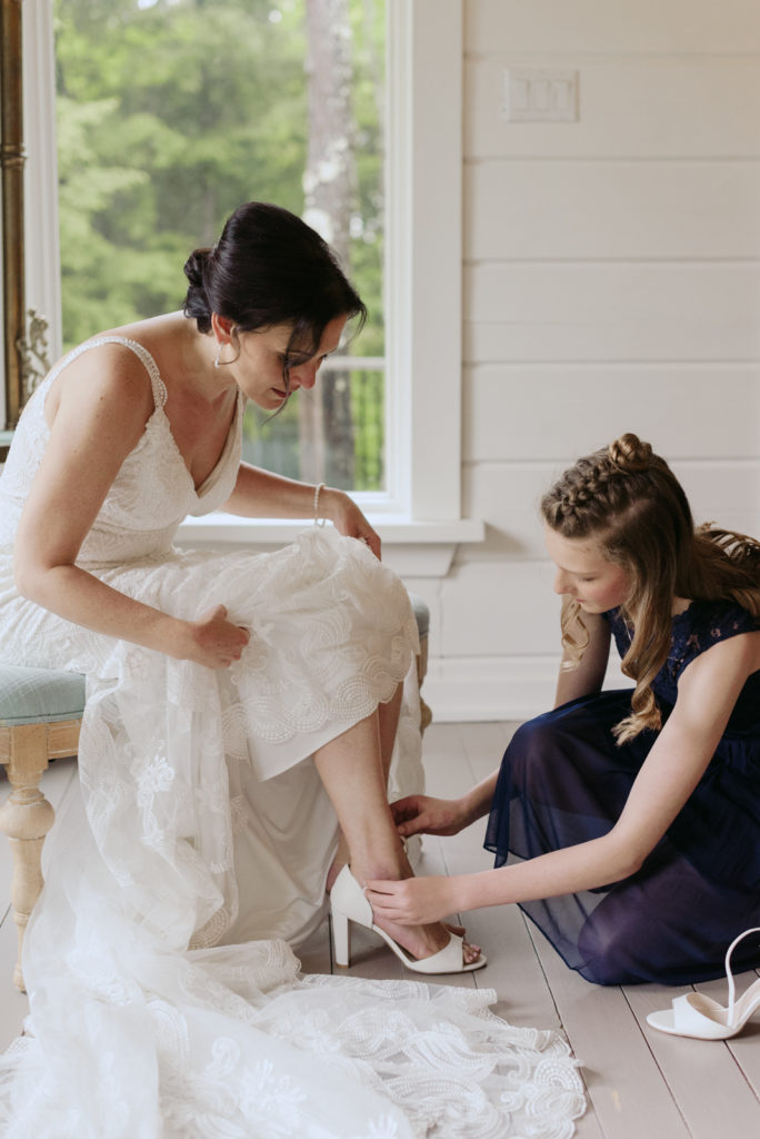 bride's daughter helping her put on her shoes