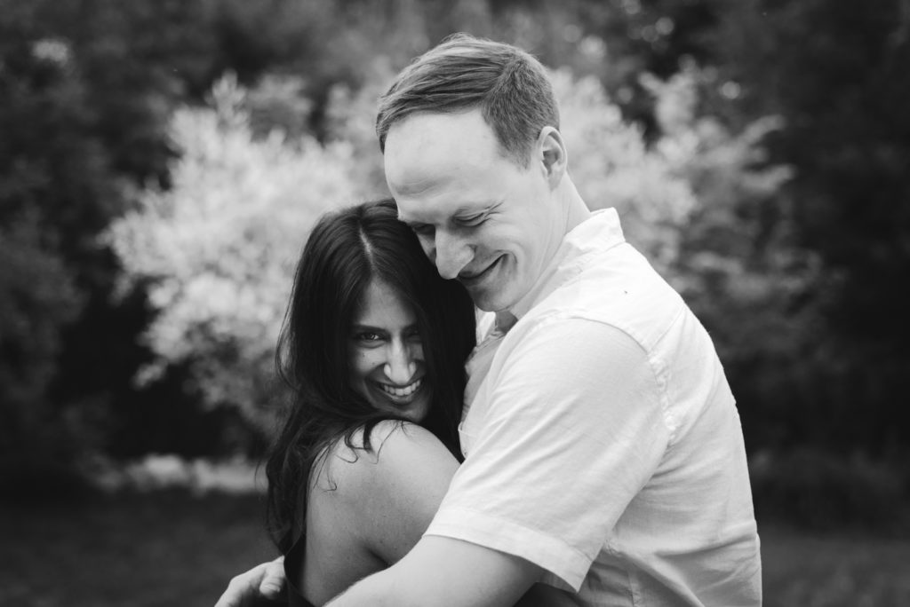 engaged couple cuddling in black and white