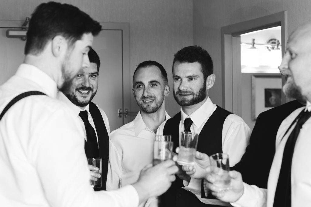 groomsmen cheersing with scotch