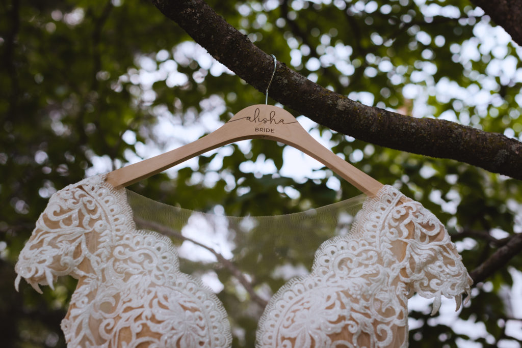 bride's dress hanging from a tree with personalized hanger