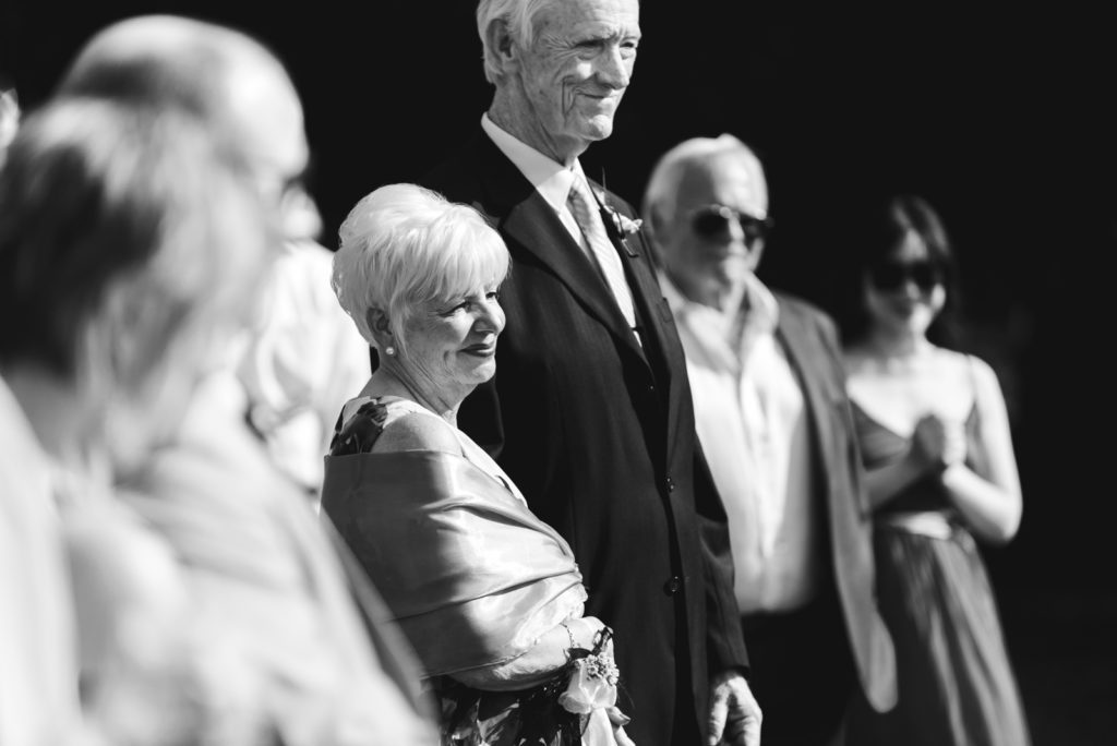 groom's parents smiling during wedding ceremony