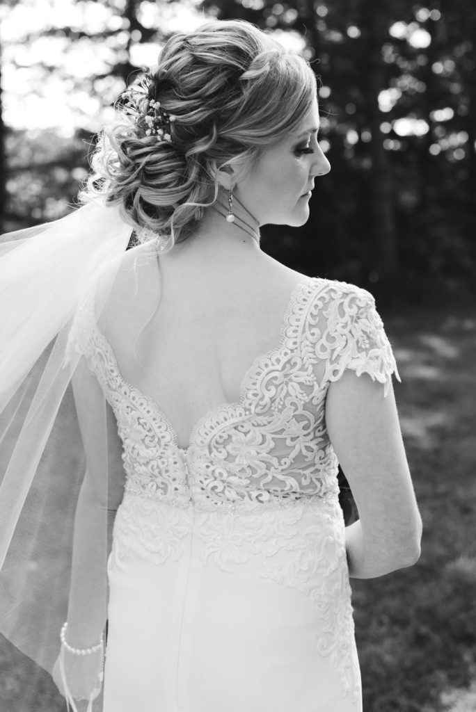 back of bride's dress with veil blowing in the wind
