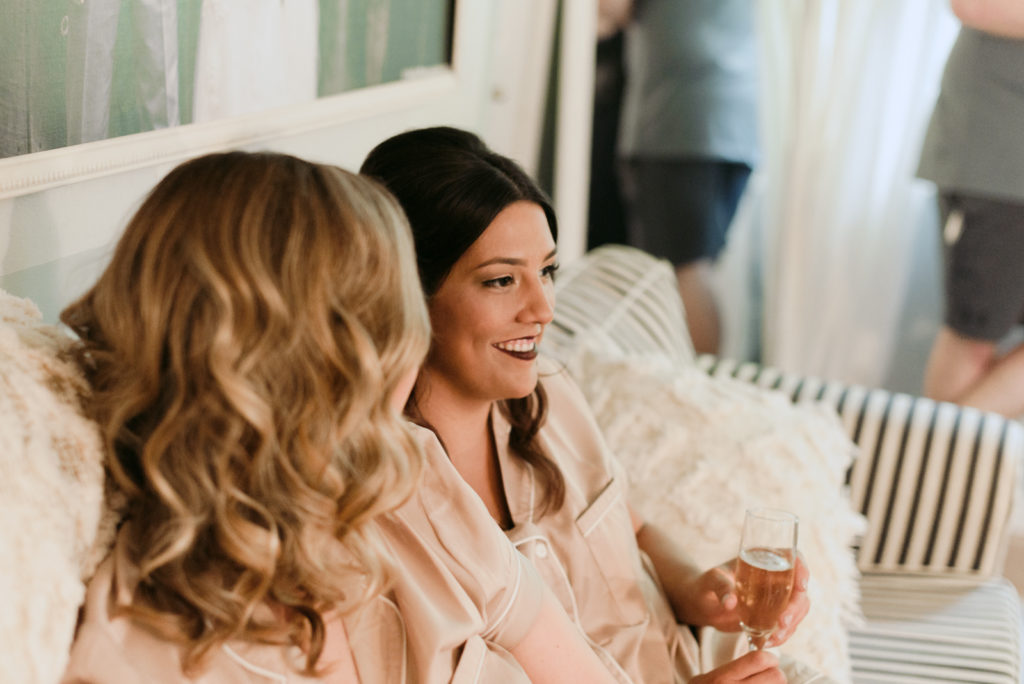 bridesmaids sitting on couch with champagne