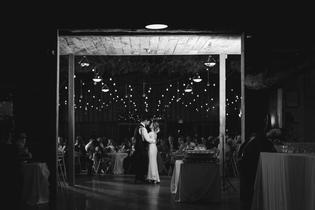bride and groom first dance under edison lights