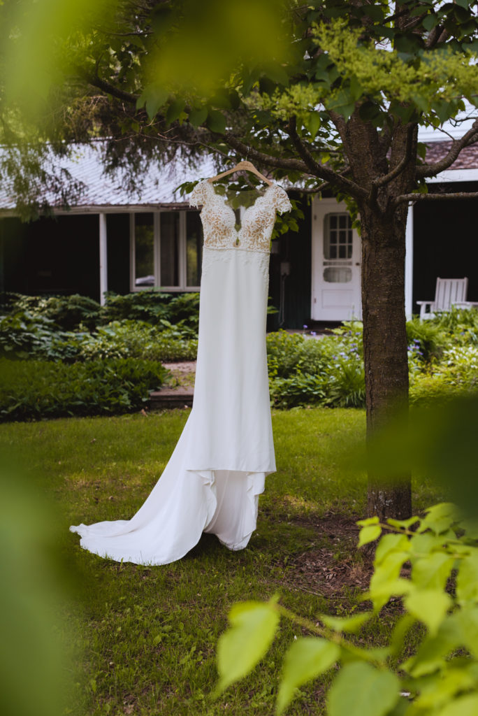 bride's dress hanging in a tree outside farm house