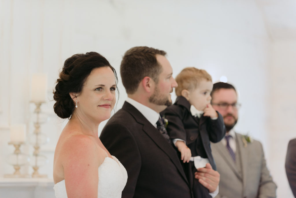 bride smiling at wedding guests during ceremony