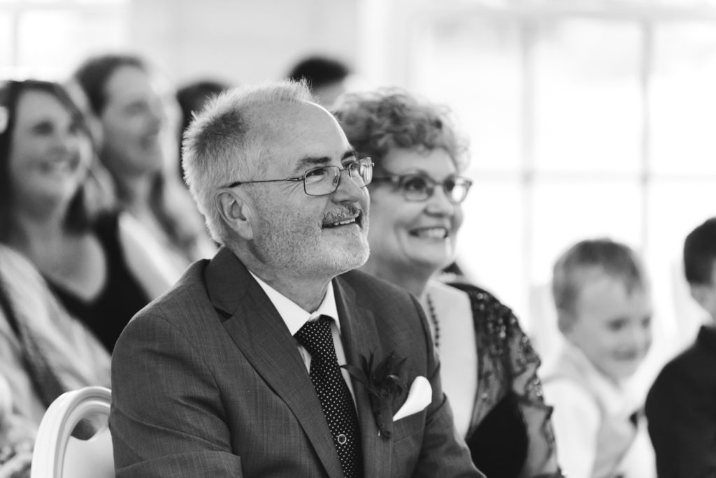groom's parents smiling during wedding ceremony