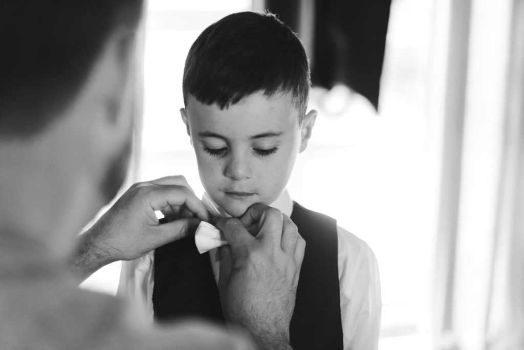 groom helping his on put on his tie