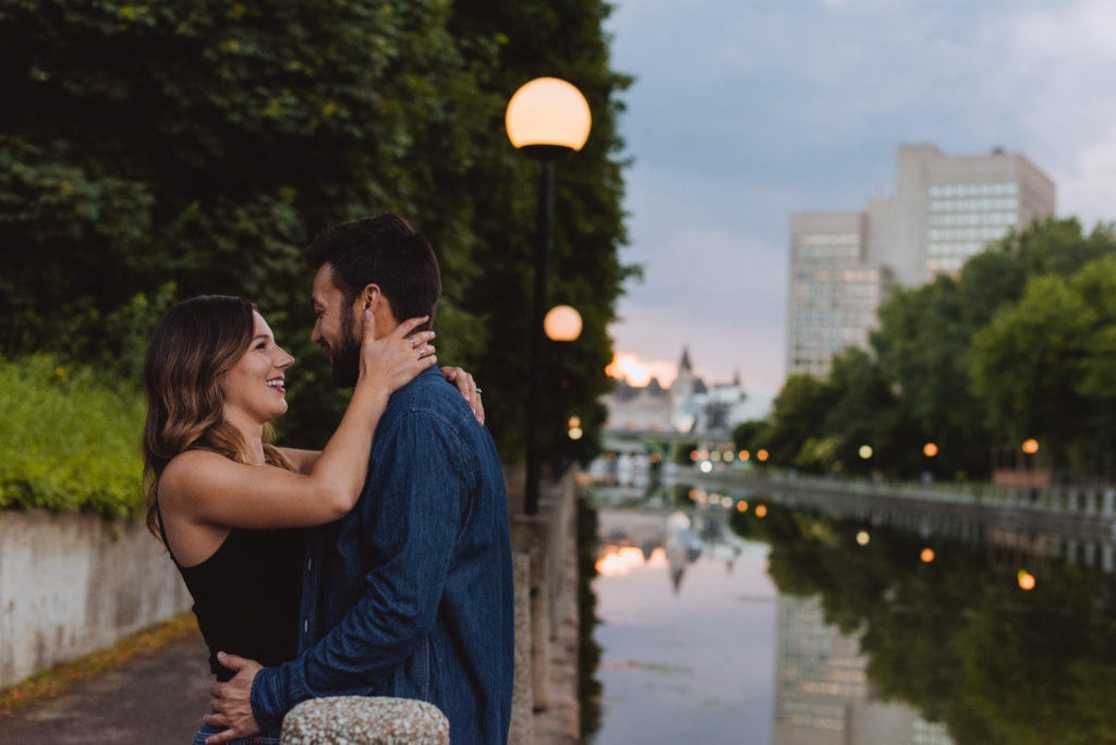 engaged couple by the canal at sunset