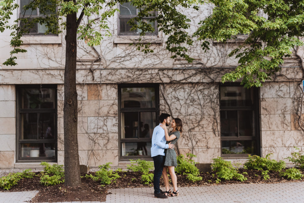 engaged couple in front of old stone building with vines