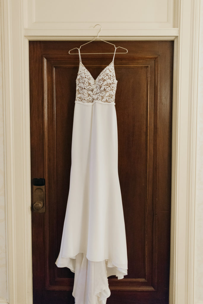 wedding dress hanging from door