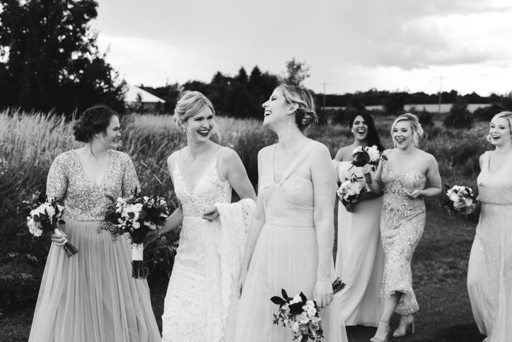 bride and bridesmaids walking and laughing at Fields on West Lake