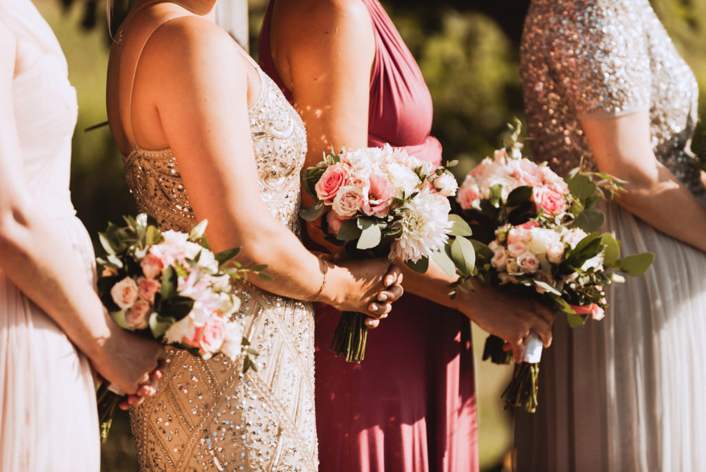 bridesmaids in sequenced dresses holding flowers