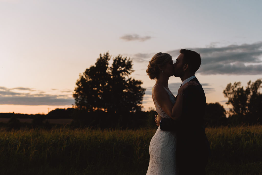 bride and groom kissing at sunset at Fields on West Lake