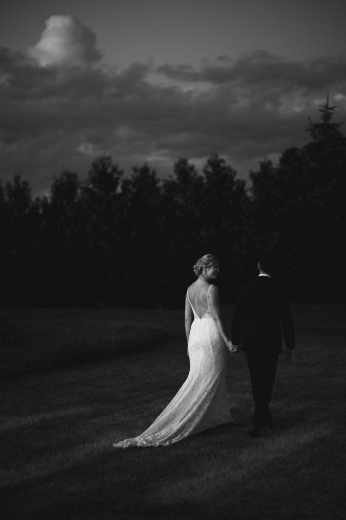 bride and groom walking at sunset at Fields on West Lake