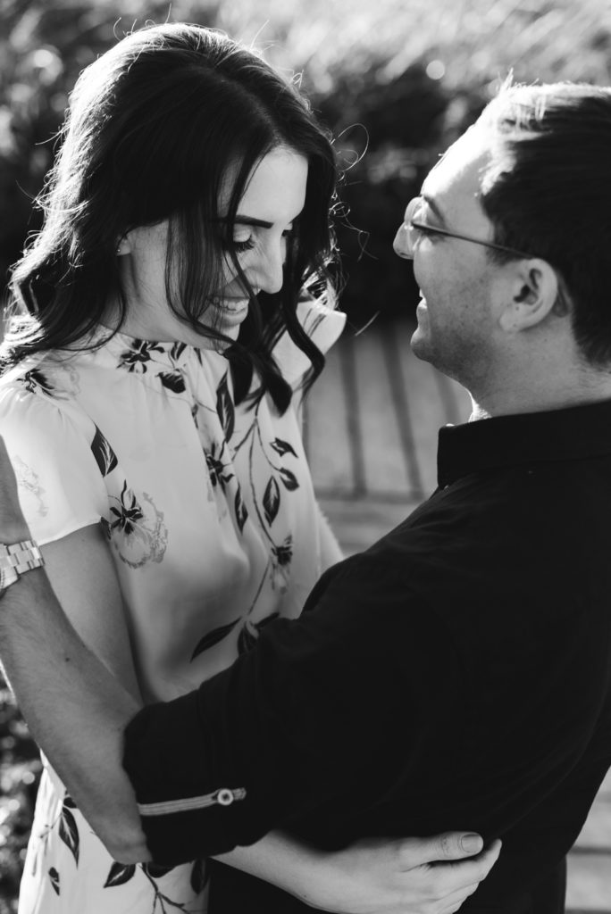 Engaged couple smiling and laughing in black and white