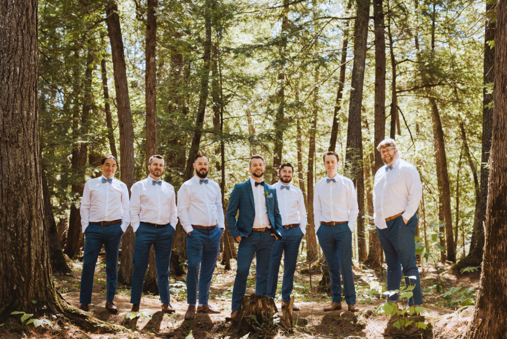 groom and groomsmen in the woods