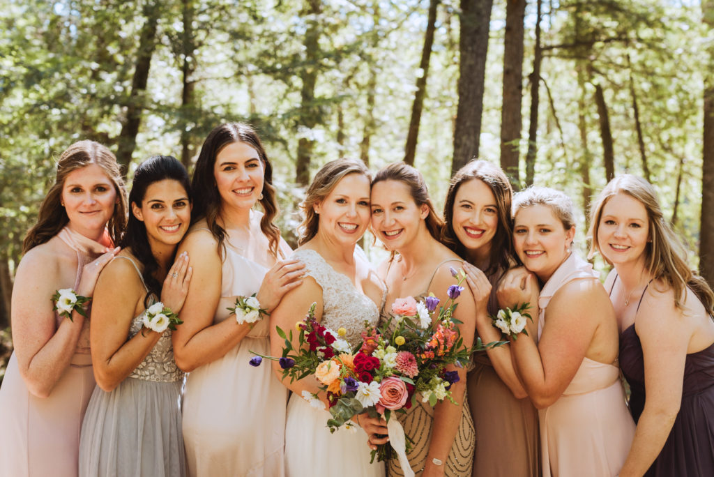 bride and bridesmaids in the woods