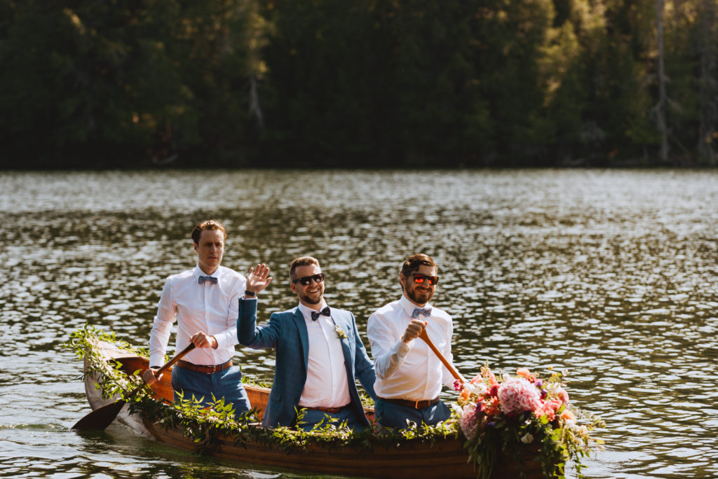 groom and groomsmen canoeing to wedding ceremony