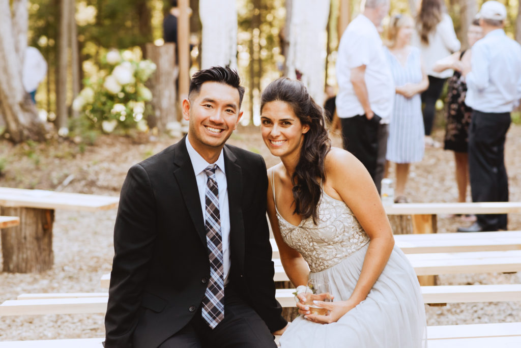 bridesmaid and her husband smiling at wedding