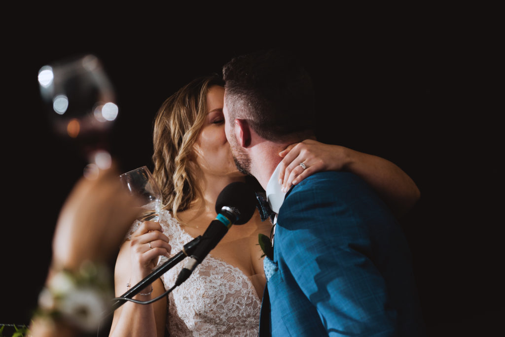 bride and groom kissing during speeches