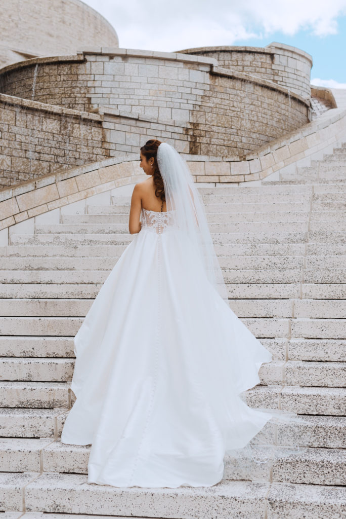 bride standing on staircase with train