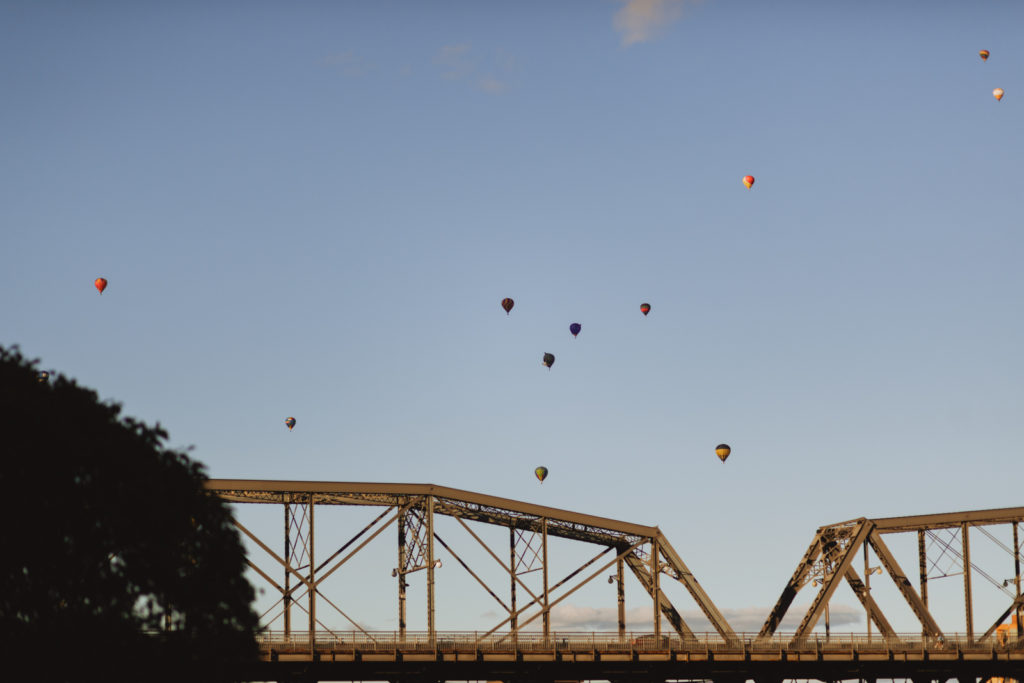 alexandria bridge with hot air balloons in the sky at sunset