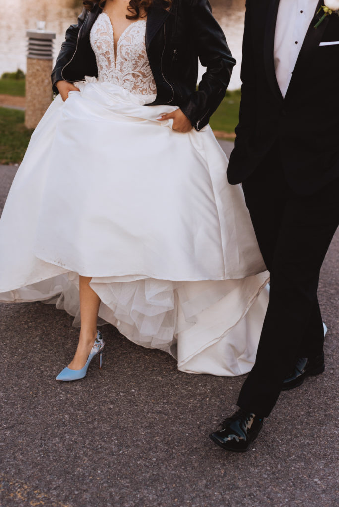 bride wearing blue shoes walking with her groom