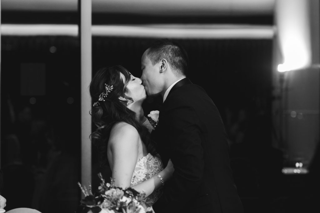 bride and groom kissing at wedding reception