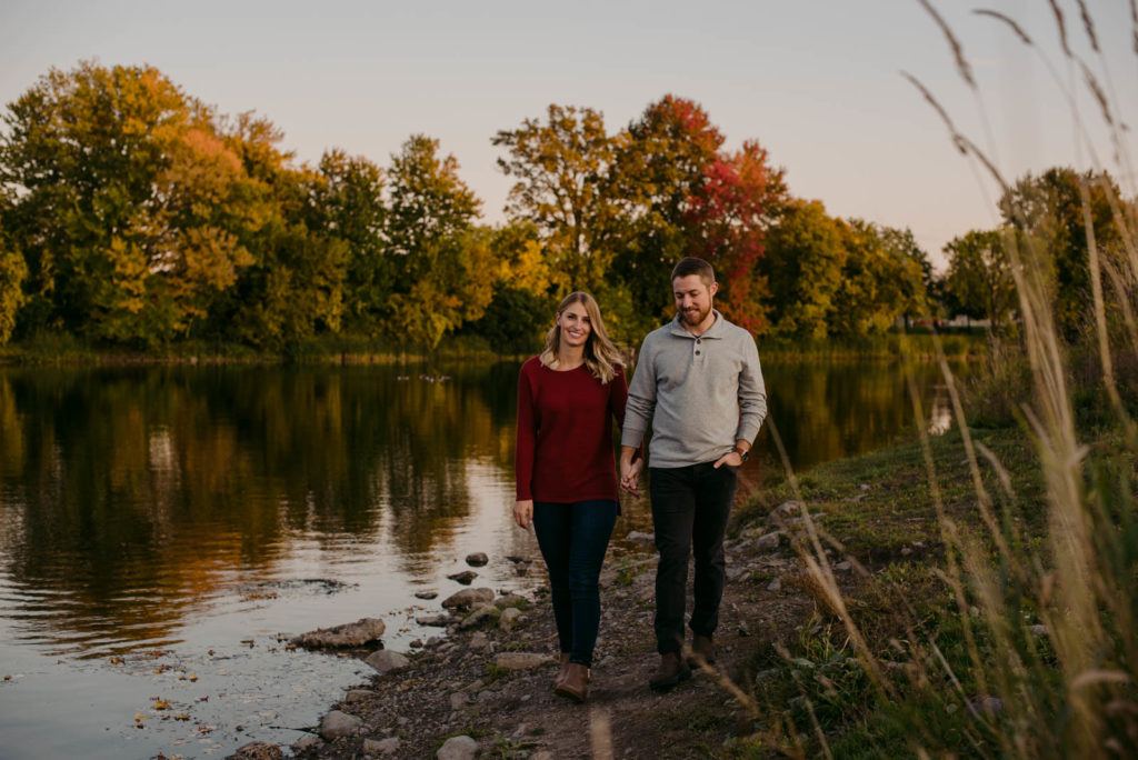 engaged couple walking along the water's edge wearing blunstones