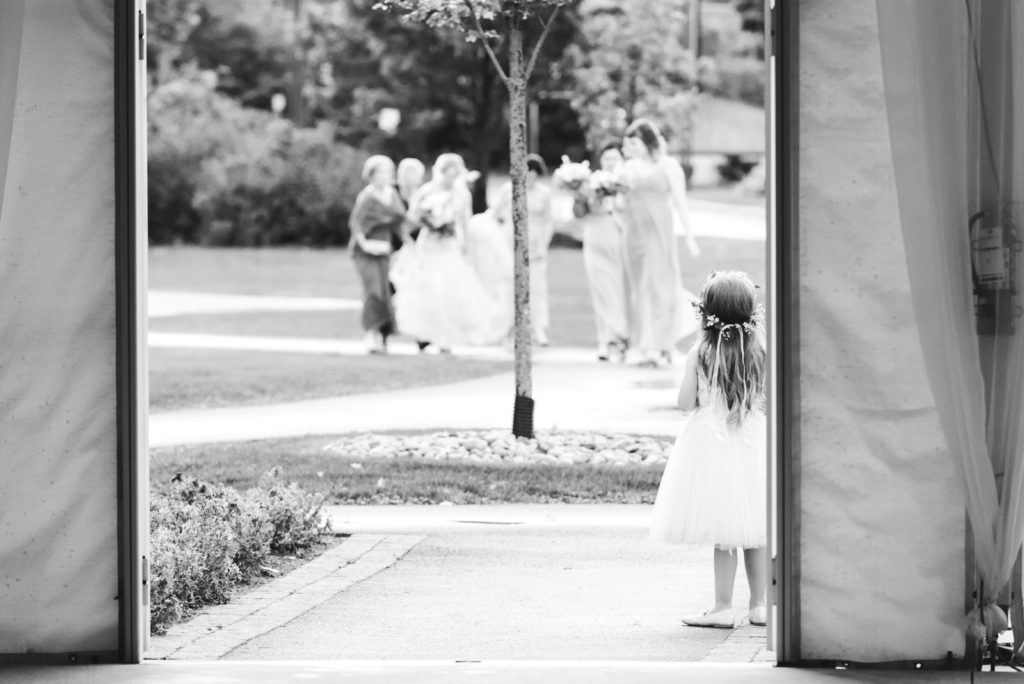 flower girl waiting for the bride and bridesmaids to walk down the aisle